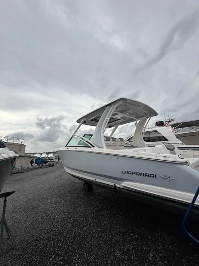  Yacht Photos Pics 2020 Chaparral 300 OSX boat on gravel lot under cloudy sky.