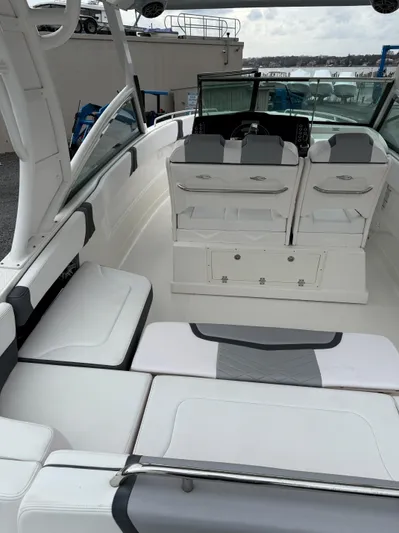  Yacht Photos Pics 2020 Chaparral 300 OSX boat interior with seating and helm, docked near water.