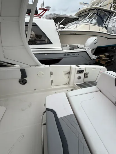  Yacht Photos Pics 2020 Chaparral 300 OSX boat interior with seating, docked near other boats.