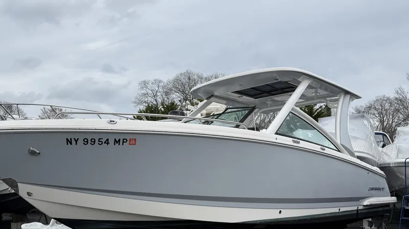  Yacht Photos Pics 2020 Chaparral 300 OSX boat with sleek design, docked under cloudy skies.