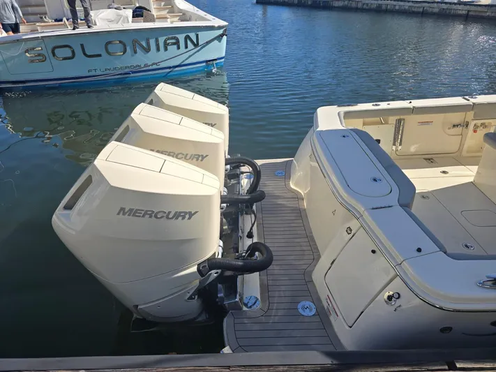  Yacht Photos Pics 2024 Scout 355 LXF boat with triple Mercury outboard engines docked in marina.