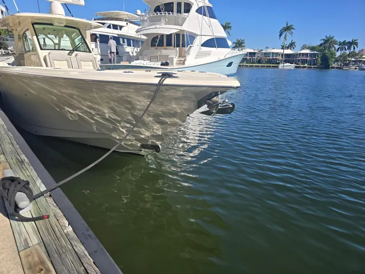  Yacht Photos Pics 2024 Scout 355 LXF boat docked in a marina with clear blue skies.