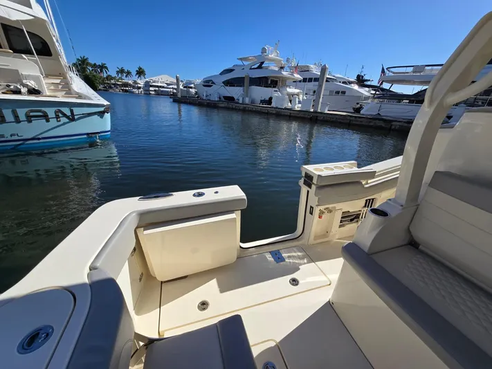  Yacht Photos Pics 2024 Scout 355 LXF boat docked in a marina with luxury yachts.