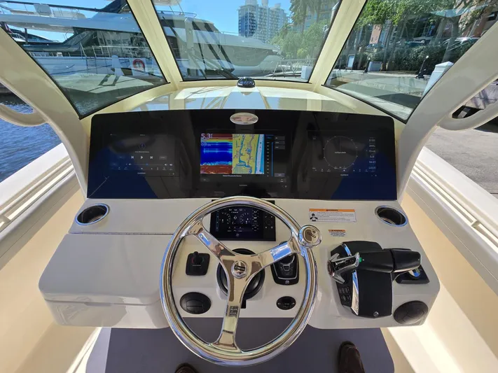  Yacht Photos Pics 2024 Scout 355 LXF boat dashboard with steering wheel and navigation screens.
