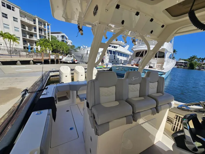  Yacht Photos Pics 2024 Scout 355 LXF boat docked, featuring luxurious seating and modern design.