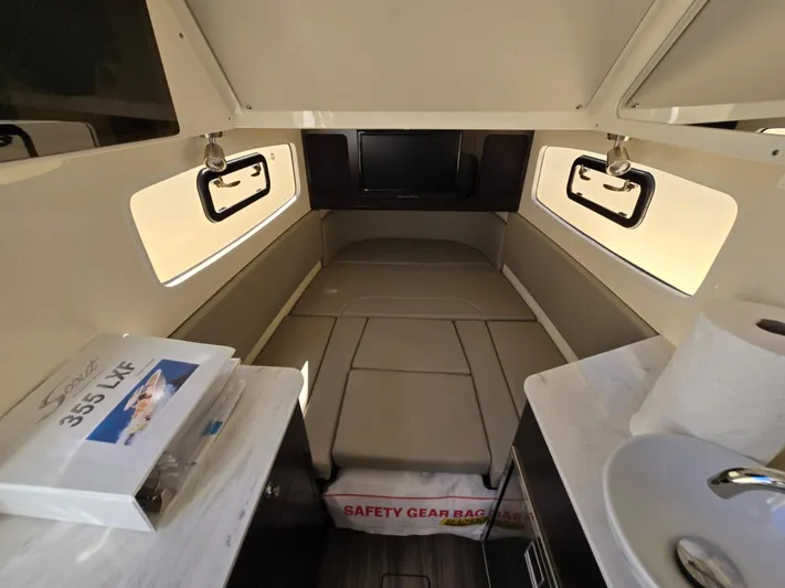  Yacht Photos Pics 2024 Scout 355 LXF cabin interior with bed, windows, and safety gear bag.