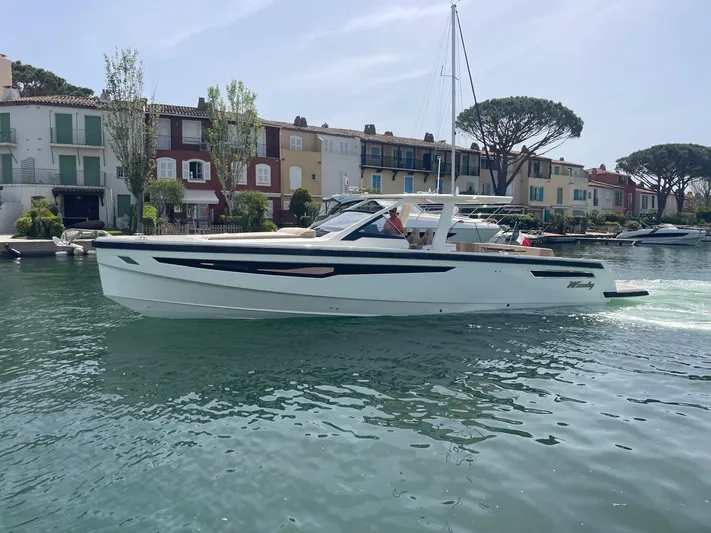  Yacht Photos Pics 2022 Windy SR 44 BLACKHAWK yacht cruising near colorful waterfront homes.