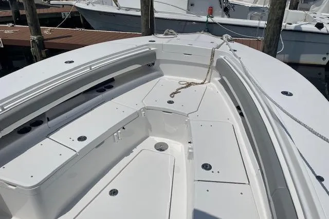  Yacht Photos Pics 2024 Regulator 28 boat deck with seating and storage, docked at marina.