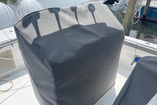  Yacht Photos Pics 2024 Regulator 28 boat console covered, docked near water.