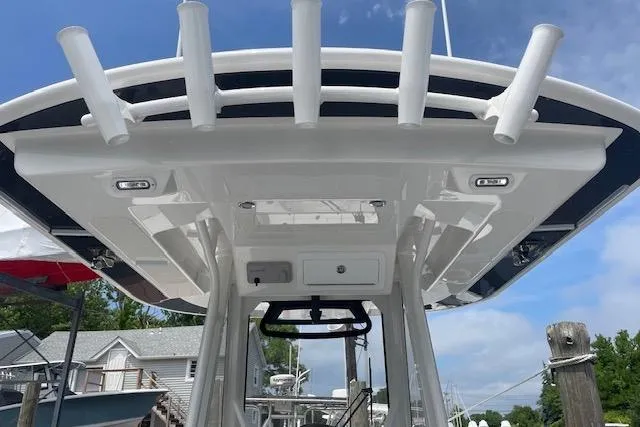  Yacht Photos Pics 2024 Regulator 28 boat with T-top and rod holders, docked under a clear sky.