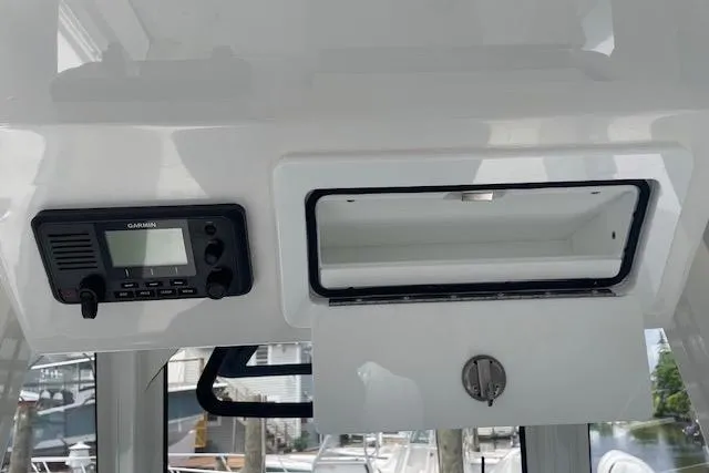  Yacht Photos Pics 2024 Regulator 28 boat interior with Garmin radio and open storage compartment.