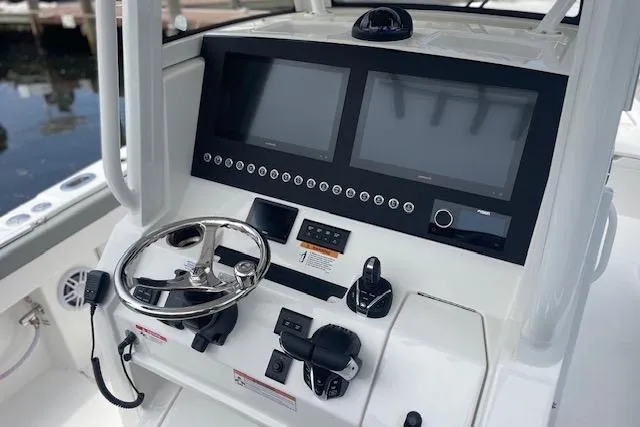  Yacht Photos Pics 2024 Regulator 28 boat dashboard with dual screens, steering wheel, and control panel.