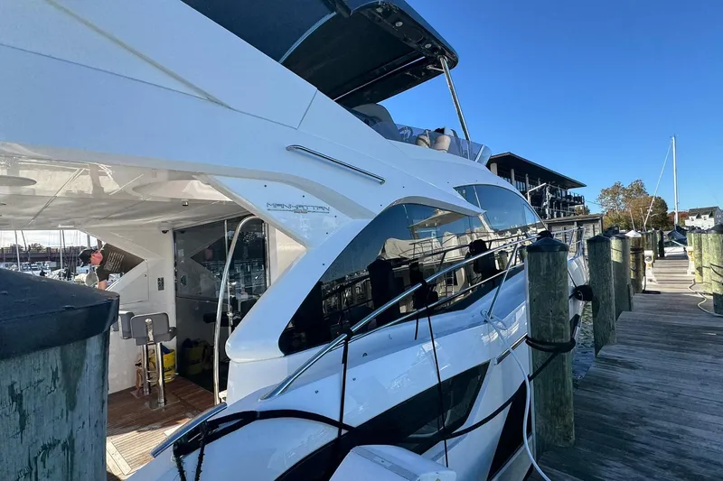  Yacht Photos Pics 2022 Sunseeker Manhattan 55 yacht docked at a marina under clear blue skies.
