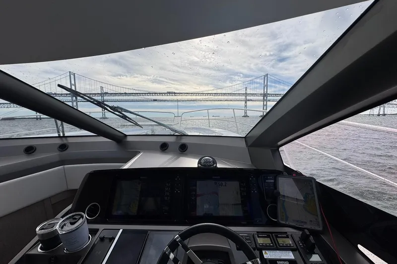  Yacht Photos Pics Interior view from 2022 Sunseeker Manhattan 55 yacht, overlooking a bridge on a cloudy day.