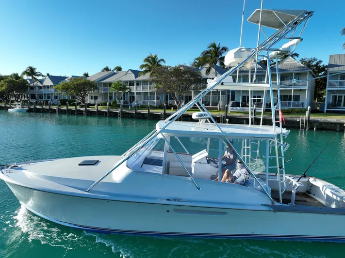 R & R Yacht Photos Pics 2000 Stolper 3800 Tournament Express boat cruising near waterfront homes.