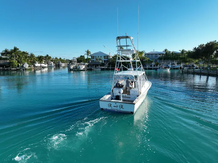 R & R Yacht Photos Pics 2000 Stolper 3800 Tournament Express boat cruising in a serene marina setting.