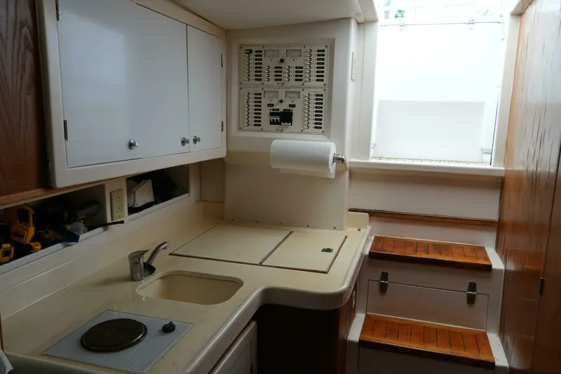 R & R Yacht Photos Pics 2000 Stolper 3800 Tournament Express boat interior with kitchenette and wooden steps.