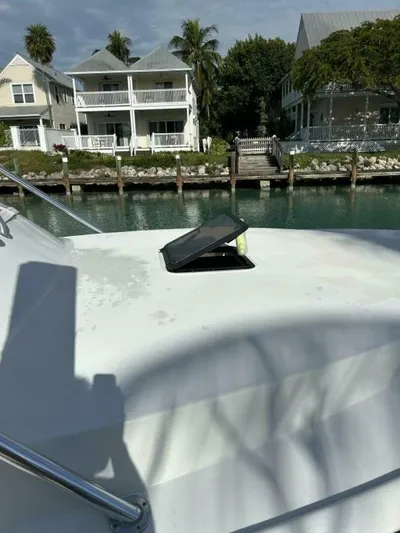 R & R Yacht Photos Pics 2000 Stolper 3800 Tournament Express boat docked near waterfront homes.