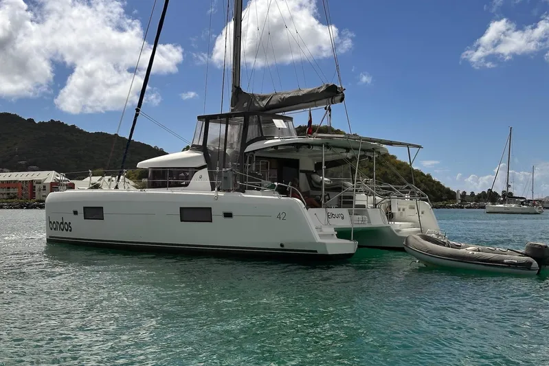  Yacht Photos Pics 2016 Lagoon 42 catamaran anchored in clear waters with scenic background.