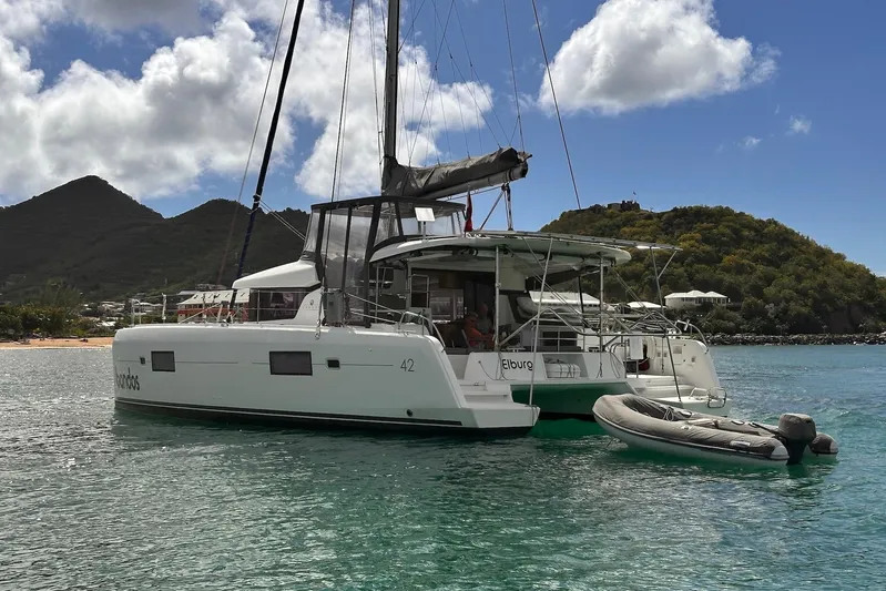  Yacht Photos Pics 2016 Lagoon 42 catamaran anchored in scenic bay with inflatable dinghy.