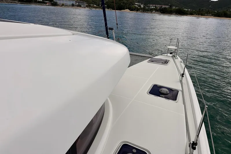  Yacht Photos Pics Lagoon 42 catamaran deck, 2016 model, sailing near a scenic coastline.