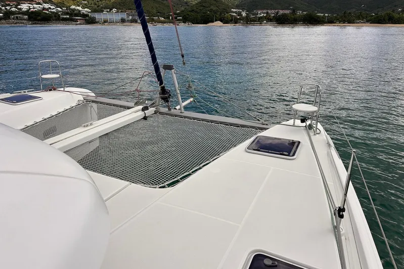  Yacht Photos Pics 2016 Lagoon 42 catamaran on calm waters, featuring spacious deck and netting.