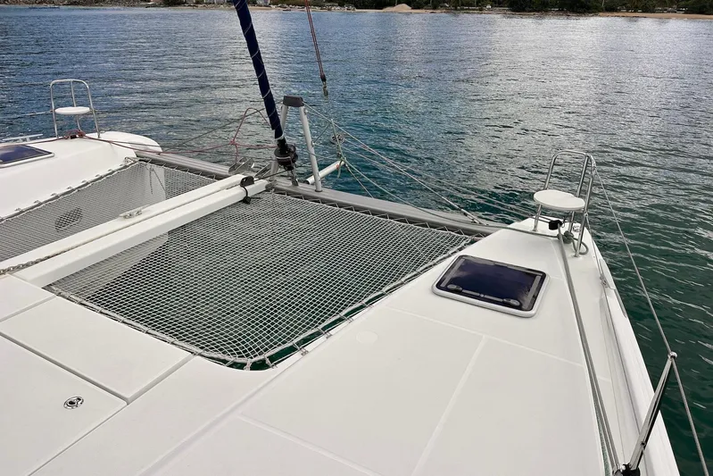  Yacht Photos Pics 2016 Lagoon 42 catamaran deck with netting, anchored on calm waters.