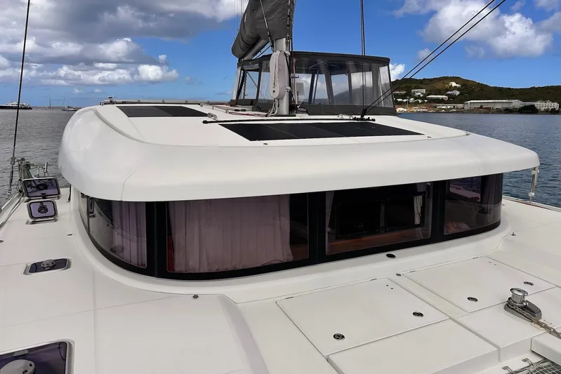  Yacht Photos Pics 2016 Lagoon 42 catamaran with sleek design, docked under a partly cloudy sky.
