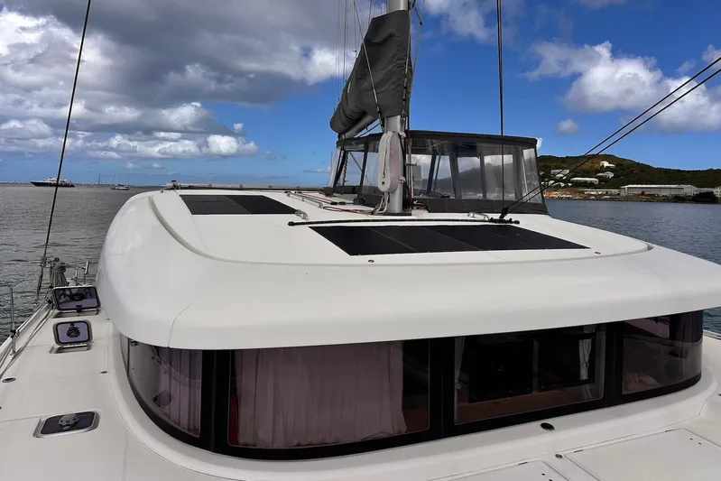  Yacht Photos Pics 2016 Lagoon 42 catamaran on calm waters under a partly cloudy sky.