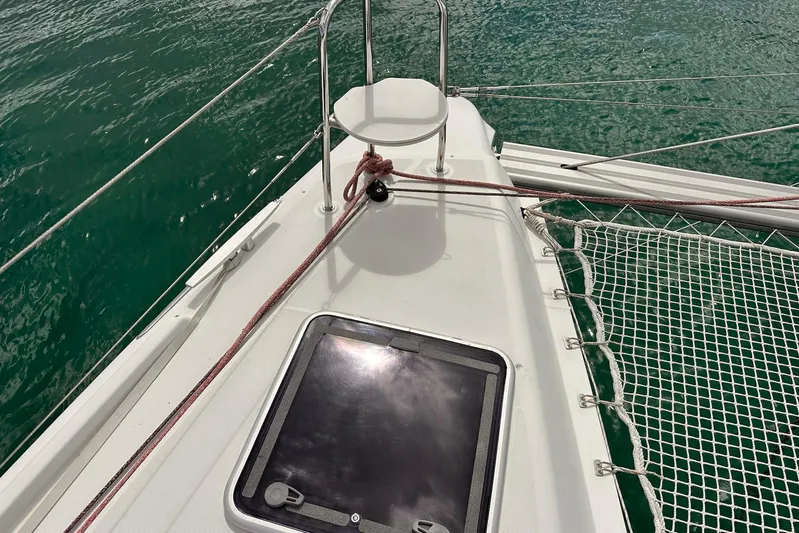  Yacht Photos Pics Bow of 2016 Lagoon 42 catamaran with netting and hatch, on calm green water.