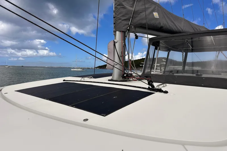  Yacht Photos Pics 2016 Lagoon 42 catamaran with solar panels, anchored under a partly cloudy sky.