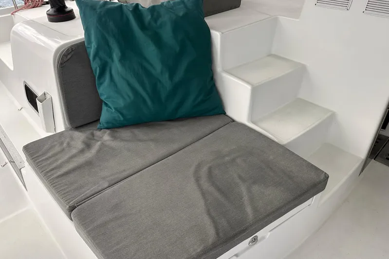  Yacht Photos Pics Cushioned seating area on 2016 Lagoon 42 catamaran with teal pillow and white steps.