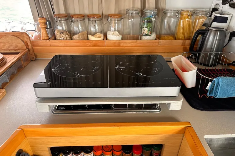  Yacht Photos Pics Modern kitchen setup on a 2016 Lagoon 42 catamaran with induction cooktop and spice rack.