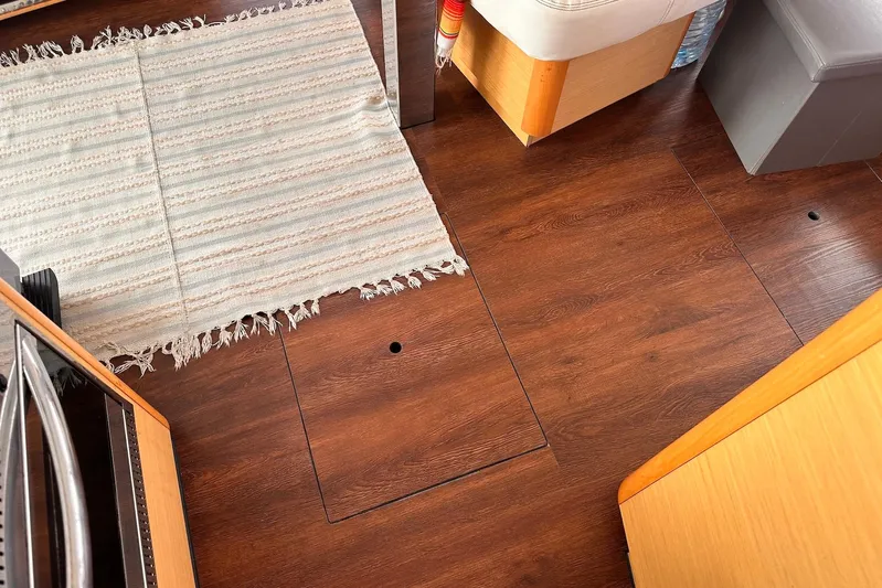  Yacht Photos Pics Interior of a 2016 Lagoon 42 yacht with wooden flooring and a striped rug.