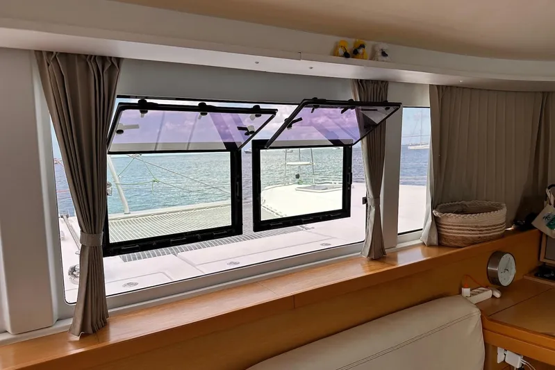  Yacht Photos Pics Interior view of a 2016 Lagoon 42 catamaran with open windows overlooking the sea.
