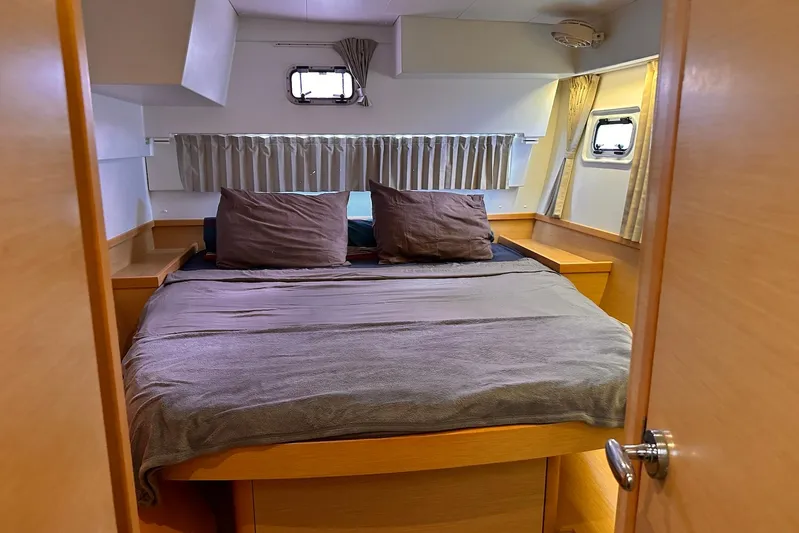  Yacht Photos Pics Cozy bedroom interior of 2016 Lagoon 42 catamaran with double bed and porthole windows.