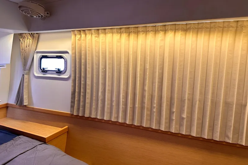  Yacht Photos Pics Interior cabin of 2016 Lagoon 42 yacht with beige curtains and wooden accents.