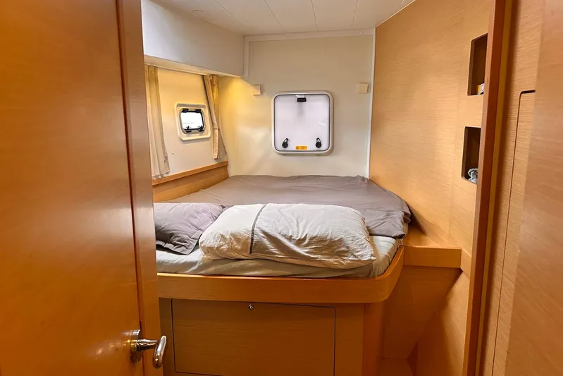  Yacht Photos Pics Cozy cabin interior of 2016 Lagoon 42 catamaran with bed and porthole window.