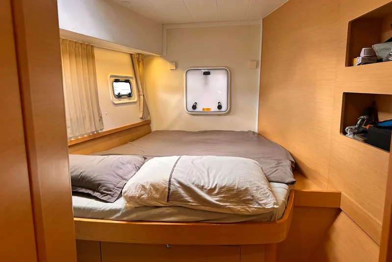  Yacht Photos Pics Cozy bedroom in 2016 Lagoon 42 catamaran with wooden interior and porthole window.