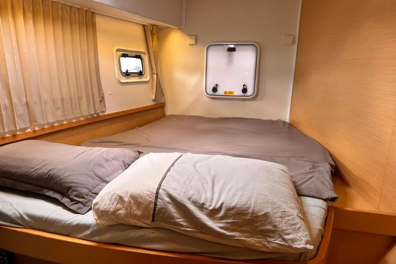  Yacht Photos Pics Cozy cabin interior of 2016 Lagoon 42 catamaran with comfortable bedding and porthole.