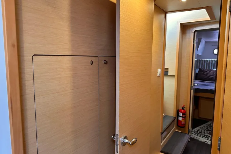  Yacht Photos Pics Interior of 2016 Lagoon 42 yacht, featuring wooden paneling, a doorway, and a fire extinguisher.