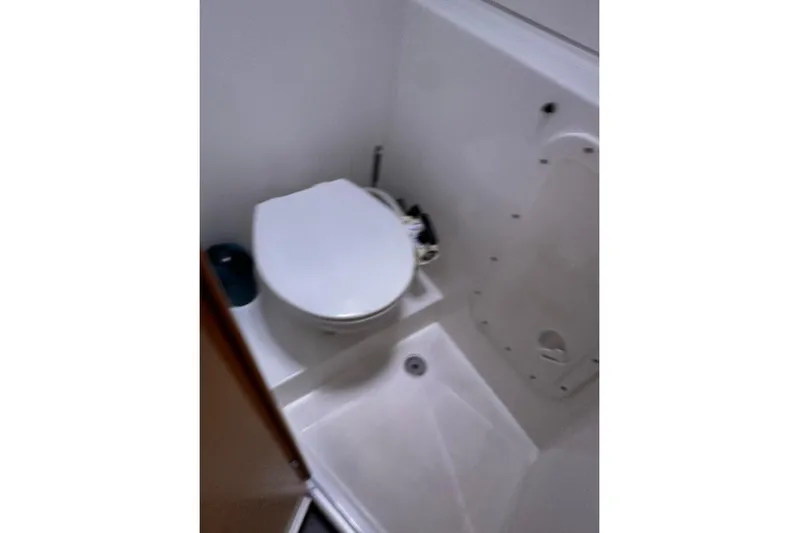  Yacht Photos Pics Bathroom interior of a 2016 Lagoon 42 catamaran, featuring a compact toilet and shower area.
