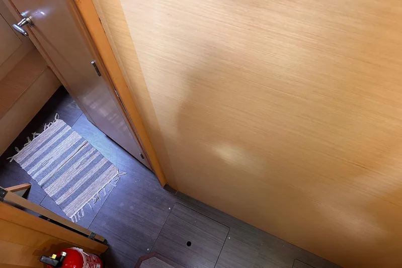  Yacht Photos Pics Interior of 2016 Lagoon 42 yacht with wooden walls, striped rug, and fire extinguisher.