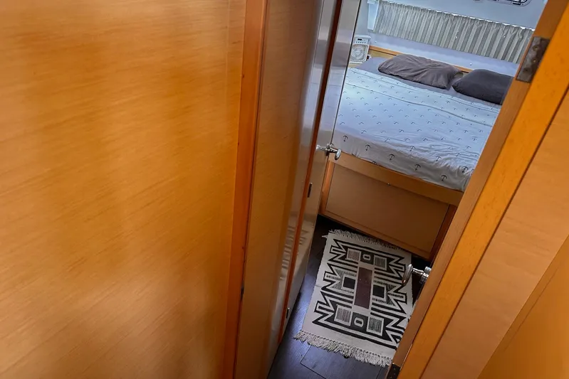  Yacht Photos Pics Cozy cabin interior of 2016 Lagoon 42 catamaran with bed and patterned rug.
