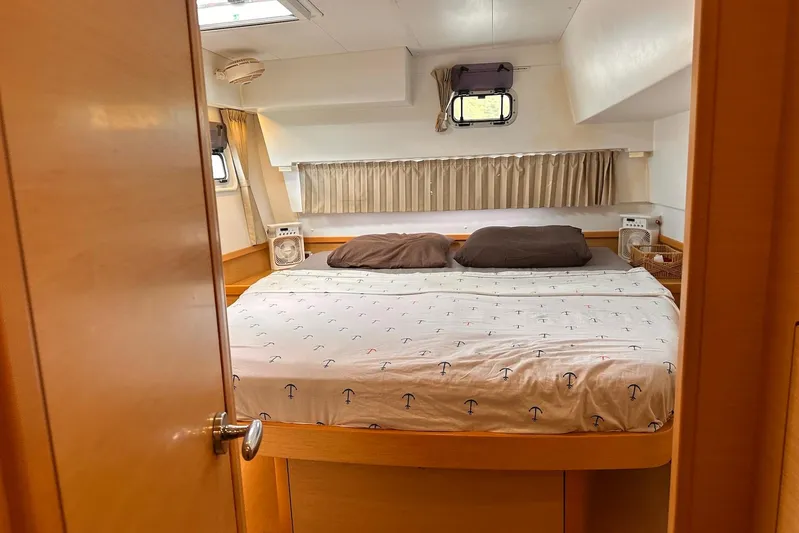 Yacht Photos Pics Cozy bedroom interior of 2016 Lagoon 42 catamaran with nautical-themed bedding.