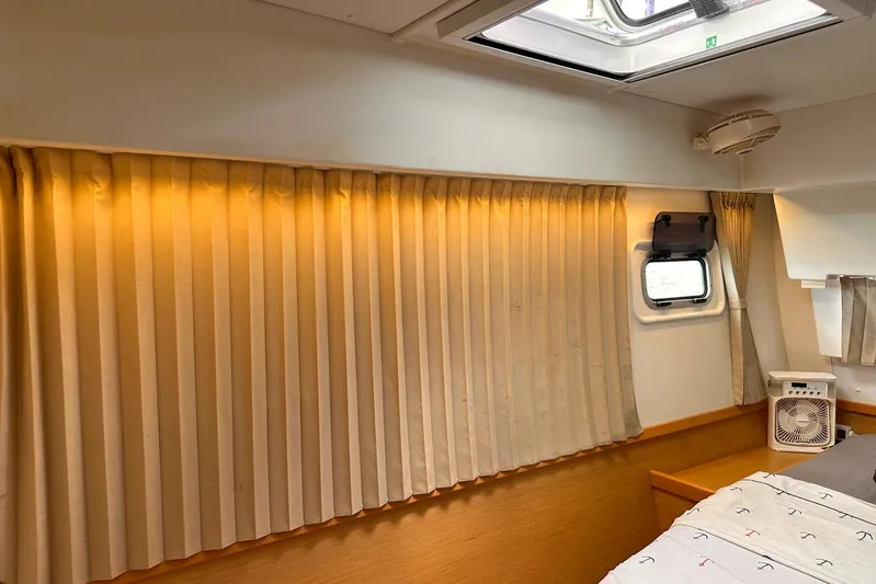  Yacht Photos Pics Cozy interior cabin of 2016 Lagoon 42 yacht with curtains and a small fan.