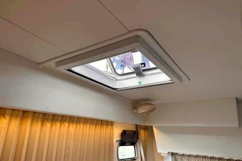  Yacht Photos Pics Interior view of a 2016 Lagoon 42 yacht with a ceiling hatch and curtains.