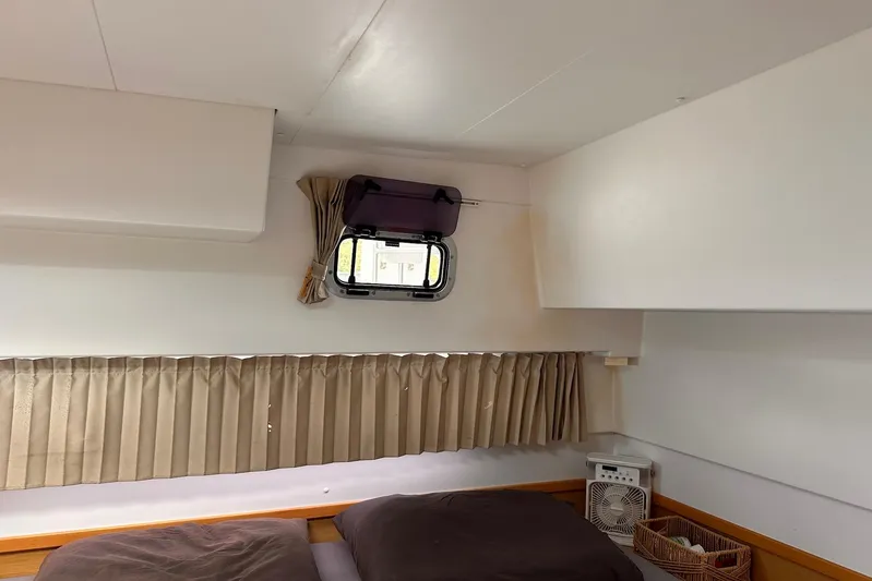  Yacht Photos Pics Interior cabin of 2016 Lagoon 42 catamaran with window, curtains, and bed.