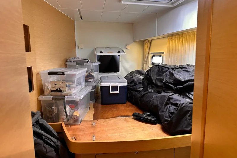  Yacht Photos Pics Interior of 2016 Lagoon 42 yacht with storage boxes and bags on wooden surface.