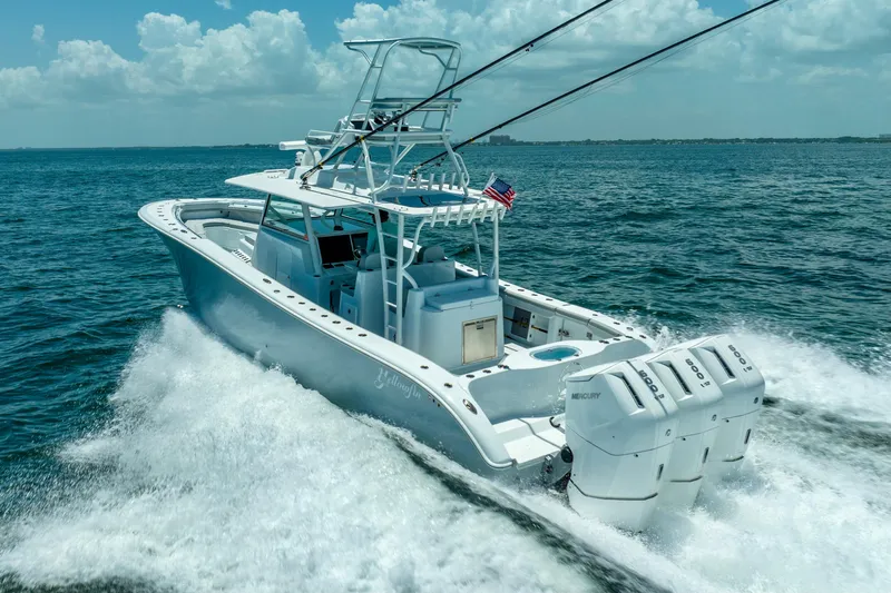  Yacht Photos Pics 2023 Yellowfin 42 Offshore boat cruising on open water, featuring triple outboard engines.